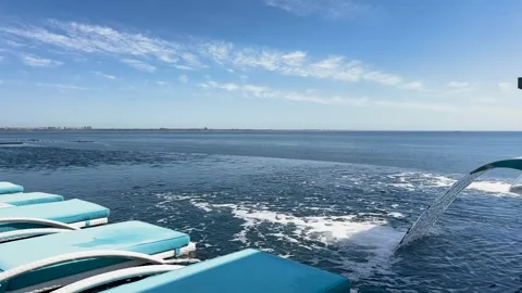 Infinity pool with blue lounge chairs and water fountain Stock Footage 335981438