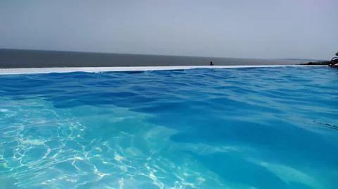 Infinity pool with blue water overlooking the sea Stock Photos
