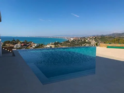 Infinity pool overlooking beautiful oropesa del mar coastline 스톡 사진