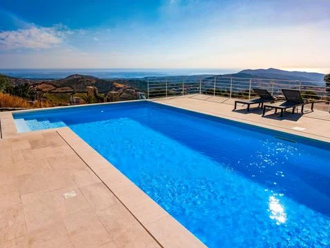Infinity Pool Overlooking the Mediterranean Sea and Hills at Sunset  Luxury.. Stock Photos