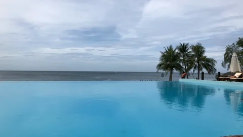 Infinity pool overlooking the ocean with palm trees in Vietnam Stock Footage 107573441