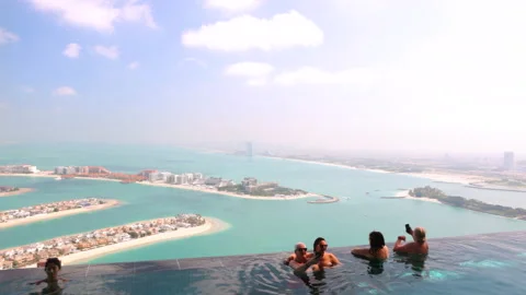 Infinity pool overlooking Palm Jumeirah and Dubai city skyline Stock Footage 237241879