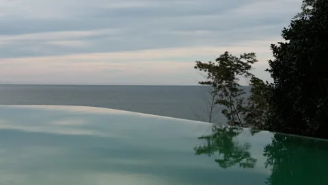 Infinity Pool Reflecting Evening Sky and Sea Horizon Video stock 347984964