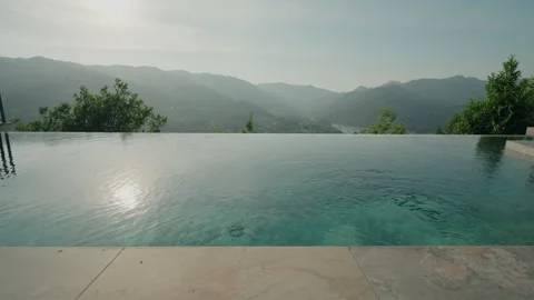 Infinity pool with ripples overlooking misty mountain valley Stock Footage 337913799
