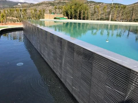 Infinity pool water overflowing into channel in oropesa del mar Foto stock
