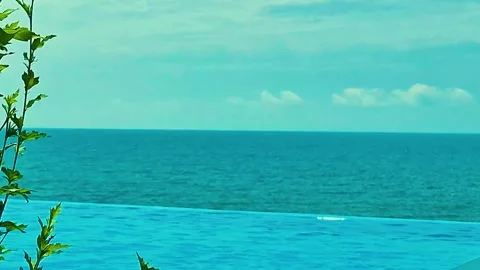 Infinity swimming pool and blue sea sky white clouds on sunny summer day slow mo Video stock 320941870