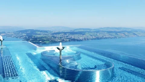 Infinity Swimming Pool with Mountain and Lake View in a Sunny Summer Day 動画素材 202523387