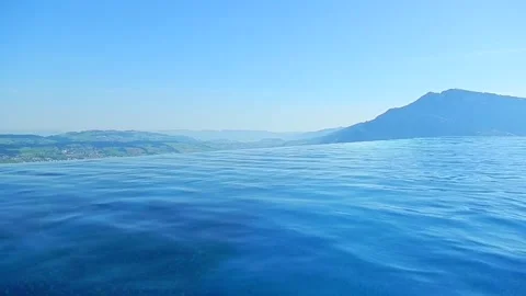 Infinity Swimming Pool with Mountain and Lake View in a Sunny Summer Day Stockbeeldmateriaal 202523904