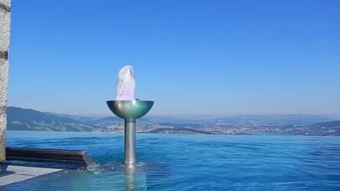 Infinity Swimming Pool with Mountain and Lake View in a Sunny Summer Day 動画素材 203484491