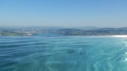 Infinity Swimming Pool with Mountain and Lake View in a Sunny Summer Day 스톡 동영상 203776958