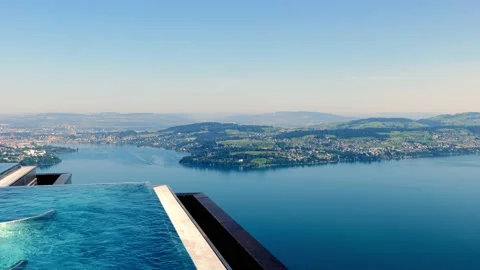 Infinity Swimming Pool with Mountain and Lake View in a Sunny Summer Day Stock Footage 203818434