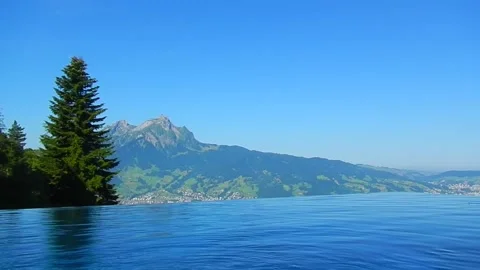 Infinity Swimming Pool with Mountain Peak View in a Sunny Summer Day Stockbeeldmateriaal 202523939