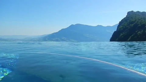 Infinity Swimming Pool with Mountain Peak View in a Sunny Summer Day Vídeo Stock 203484489