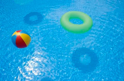 An inflatable ball and ring floating in a swimming pool Foto stock