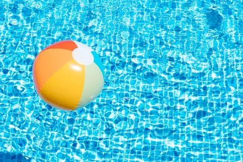An inflatable ball on a pool water background. concept of summer and travel. Stock Photos