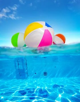 Inflatable balls float in water, split underwater pool image Stock Photos