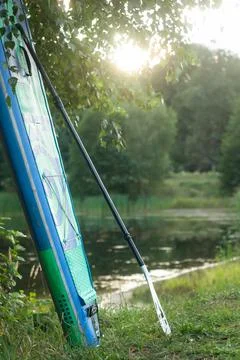 Inflatable board and paddle on the background of the lake on a summer day Foto stock