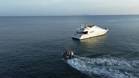 An inflatable boat takes guests back on board a private luxury yacht Stock Footage 258143371