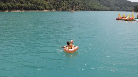 Inflatable circle on an emerald mountain lake Stock Footage 111928124