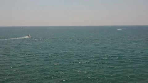 Inflatable couch raft pulled by sea motor boat on sunny day. drone aerial Stock Footage 143893980