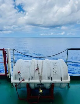 Inflatable Liferaft Container Mounted on Cargo Ship Deck with Ocean Background Stock Photos