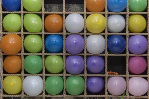 Inflatable multi-colored balls in the cells for playing darts, close up Stock Photos