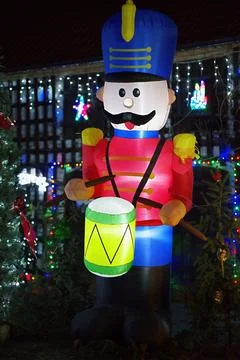 Inflatable nutcracker playing drum in outdoor christmas display with string.. Stock Photos