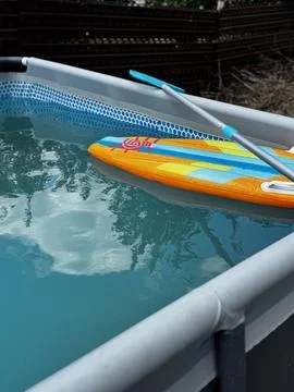 Inflatable Paddle Board Floating in Pool Stock Photos
