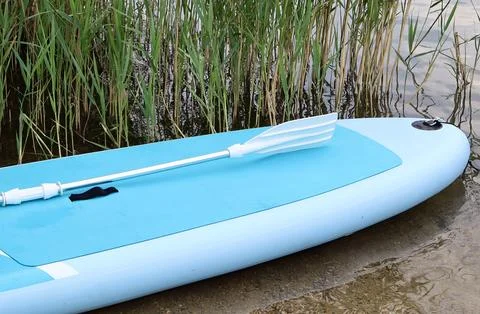 Inflatable paddle board with plastic paddle resting Stock Photos