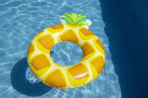 Inflatable pineapple ring floating in swimming pool Stock Photos