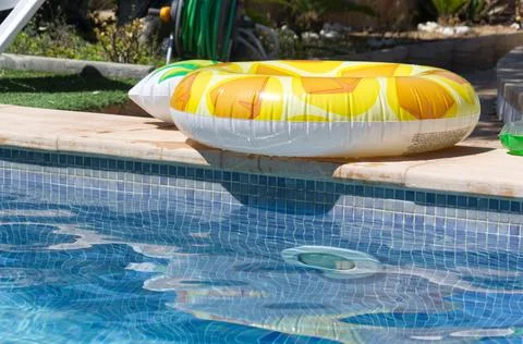Inflatable pineapple ring floating in swimming pool Stock Photos
