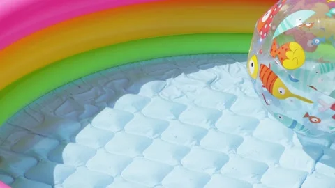 Inflatable pool and ball in backyard in summer. Relaxation and vacation on sunny Stock Footage 276895427