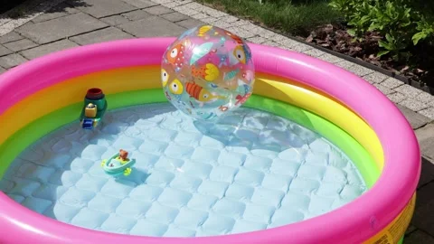 Inflatable pool and ball in backyard in summer. Relaxation and vacation on sunny Stock Footage 276955831