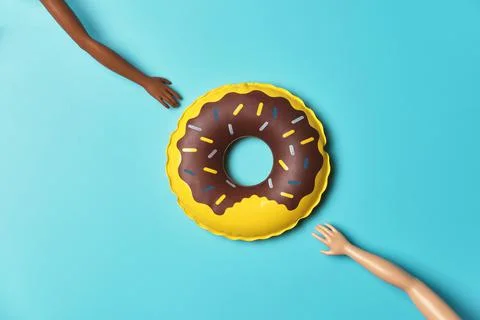 Inflatable pool float toy and two doll hands Stock Photos