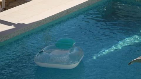 Inflatable pool floats in private villa pool during hot summer. Sunlight reflect Stock Footage 342328952