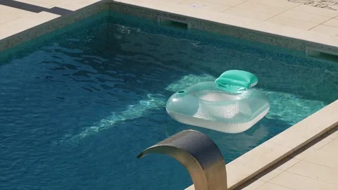 Inflatable pool floats in private villa pool during hot summer. Sunlight reflect Stock Footage 342329102