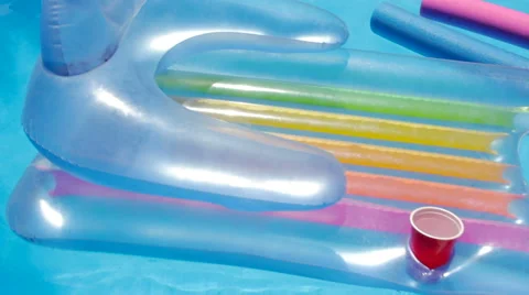 Inflatable Pool Raft Floats With a Red Cup in the Cupholder Stock Footage 64111646