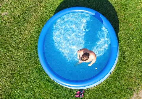 Inflatable pool, a young man in the pool, near the swimming pool. Top view Foto stock