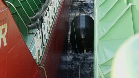 Inflatable protective buoy floats on waves between tankers Video stock 121119891