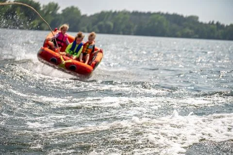 Inflatable raft being pulled at a high speed by a boat in a recreational Stock Photos