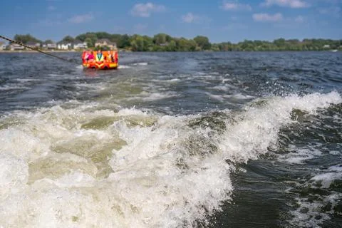 Inflatable raft being pulled at a high speed by a boat in a recreational Stock Photos