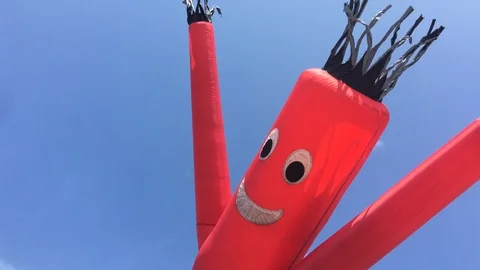 Inflatable red character blows around in the wind HD Stock Footage 116055738