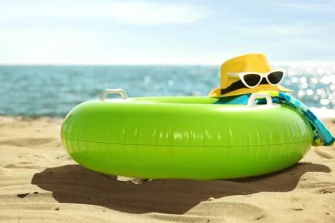 Inflatable ring and beach objects on sand near sea Stock Photos