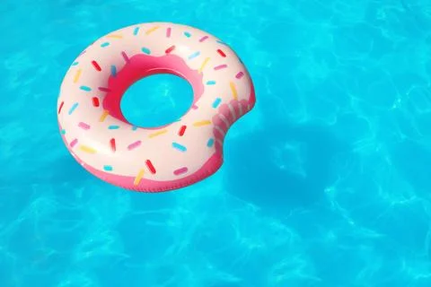 Inflatable ring floating in swimming pool on sunny day. Space for text Stock Photos