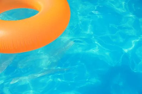 Inflatable ring floating in swimming pool on sunny day. Space for text Stock Photos