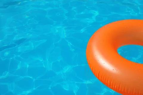 Inflatable ring floating in swimming pool on sunny day. Space for text Stock Photos