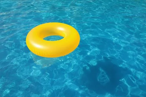 Inflatable ring floating in swimming pool on sunny day. Space for text Stock Photos
