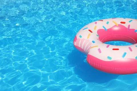 Inflatable ring floating in swimming pool on sunny day. Space for text Stock Photos