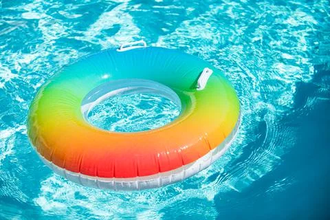 Inflatable rubber ring floating in a blue water in pool. 스톡 사진