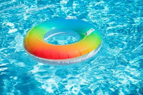 Inflatable rubber ring floating in a blue pool. 스톡 사진